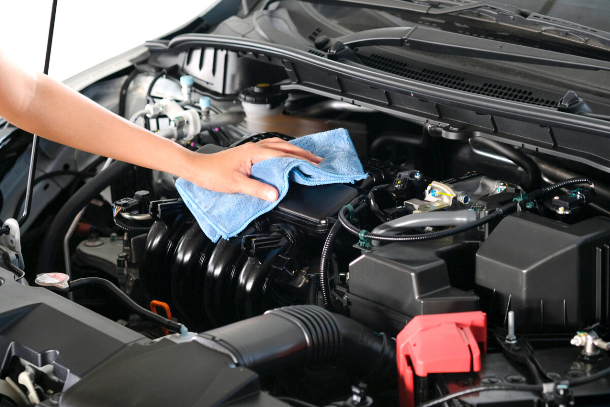 Man Cleaning Car Engine Holding Blue Cloth