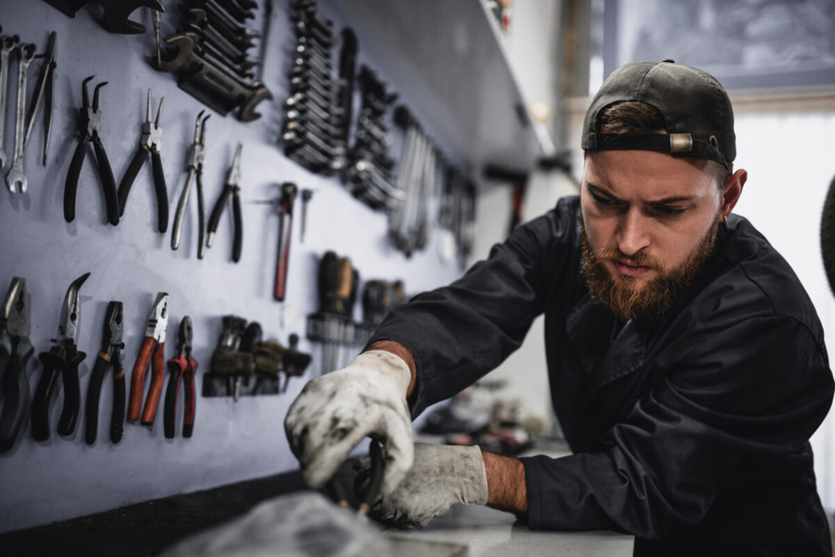 Mechanic Working On Car Part Separately On A Board