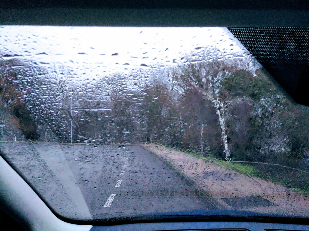 Raindrops on windshield, driving in bad weather.