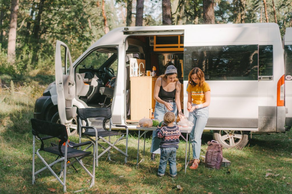 Women and Boy Cooking Outside Van